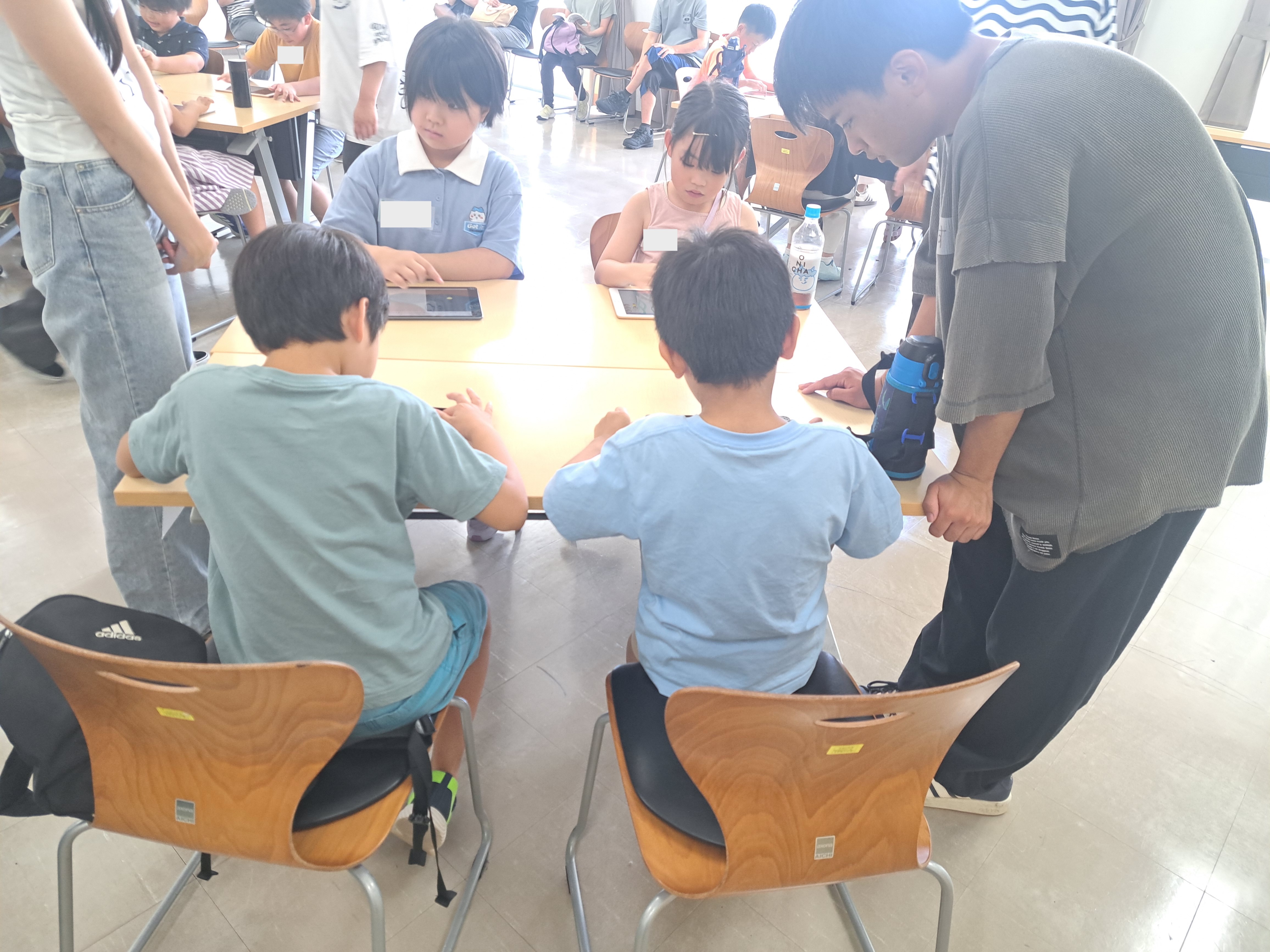 タブレットでビスケットのゲームづくりに取り組む子どもたち