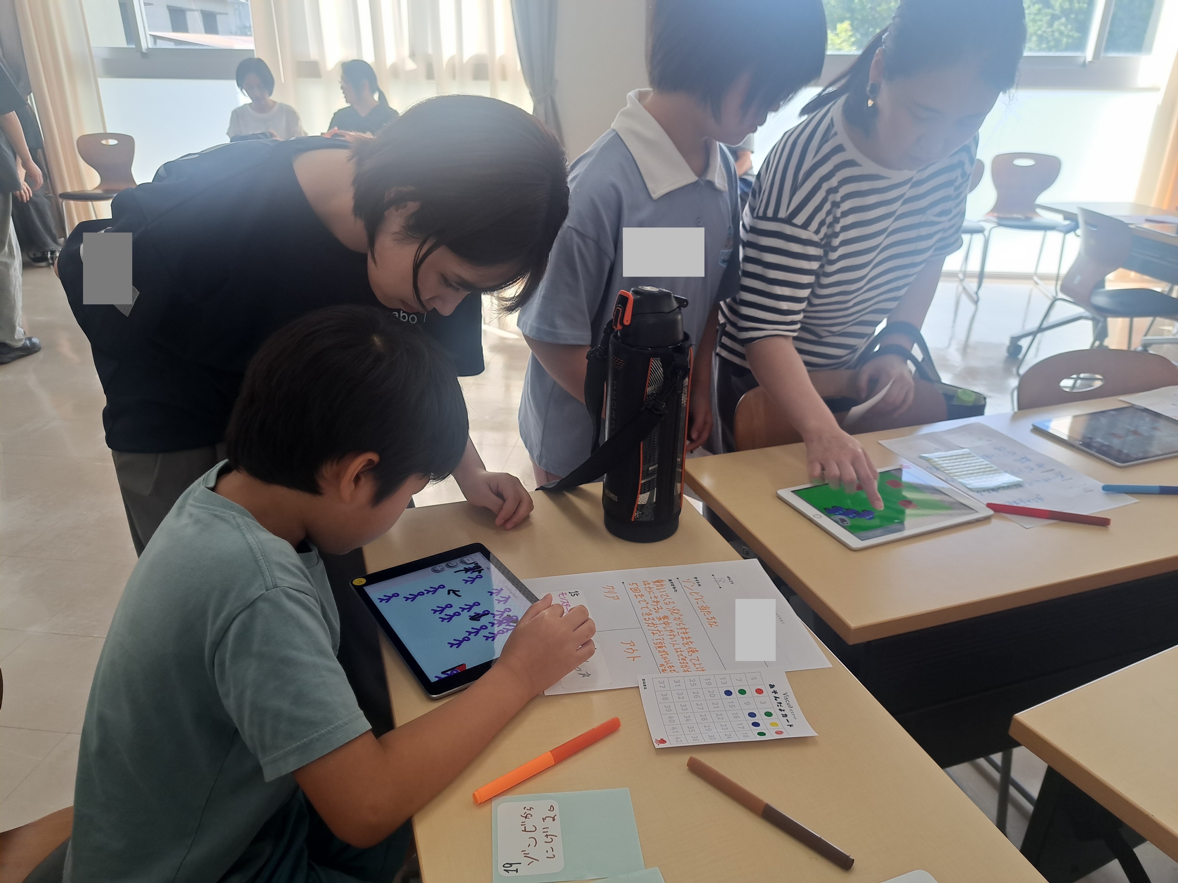 ビスケットのゲームで遊ぶ子どもたちとサポートスタッフ